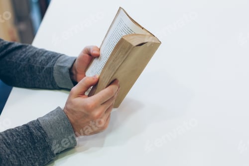 Vista previa: Young man reading open old paper book
