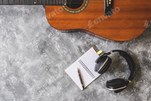 Preview: Top view of Guitar with headphone,pen and notebook on grunge background