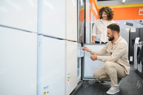 Preview: Couple choosing refrigerator in electronics store examining home appliances