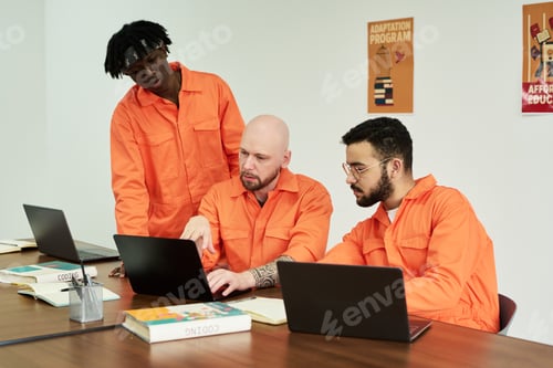 Preview: Multiethnic Young Adult Men Collaborating on Laptops during Training Session