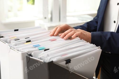 Preview: Woman taking documents from folder in archive, closeup