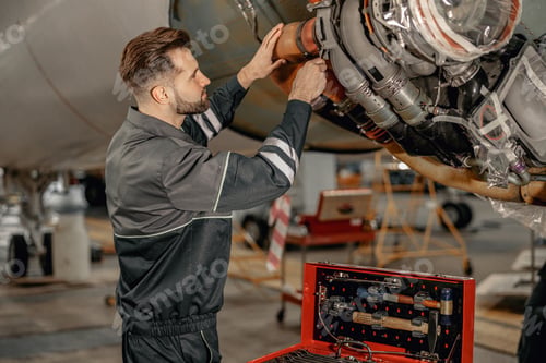 Preview: Male airline mechanic repairing aircraft in hangar