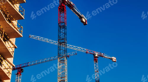 Preview: Construction cranes work on creation site against sky background