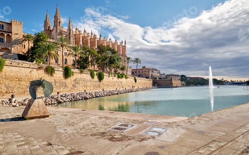 Preview: Low-angle view of the Cathedral La Seu and pool with a fountain in Mallorca, Spain
