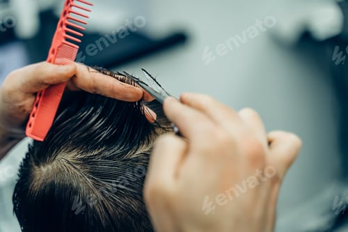 Preview: Tattooed Barber cuts the hair of the client with scissors. Close up. Attractive male is getting a