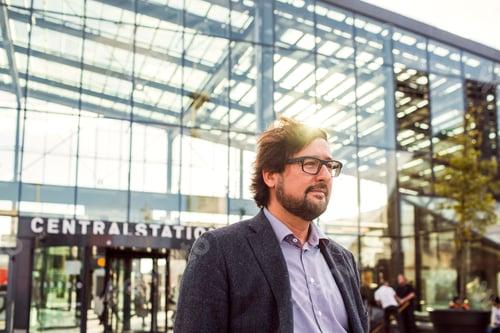Preview: Thoughtful businessman standing outside central station