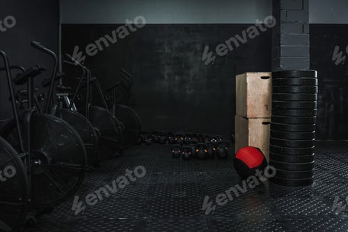 Preview: Empty dark gym with lots of crossfit equipment.