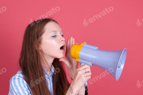 Preview: Little kid girl 13 years old in blue dress isolated on pink background whispering in megaphone