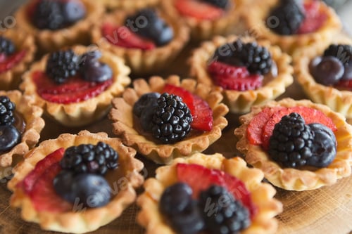 Preview: Berry tartlets dessert on wooden background