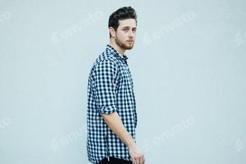 Preview: Young Man in Checkered Shirt Looking at Camera