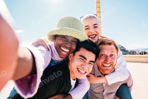 Preview: Group of friends giving piggyback ride to girlfriends. Happy young friends enjoying a weekend day.