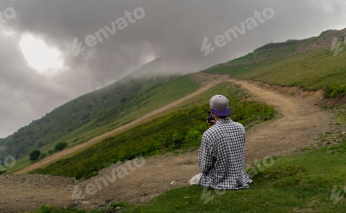 Preview: Solitary Man Hiking on a Scenic Mountain Trail Under an Overcast Sky at Dusk