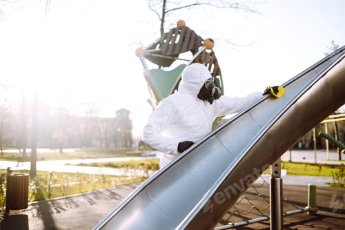 Preview: Man wearing protective suit washes and disinfecting playground to preventing the spread of epidemic