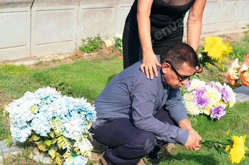Preview: Woman comforting sad man visiting grave at cemetery