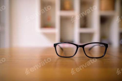 Preview: Eyeglasses on Wood Table with Blurred Background