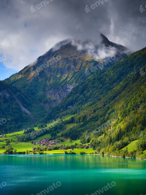 Preview: Lungern, canton of Obwalden, Switzerland. A view of rural homes in a green meadow.