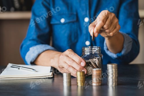 Preview: Saving Money in Jar at Desk Indoors