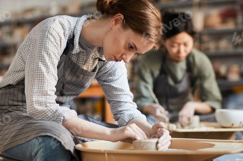 Preview: Serious woman making pot in workshop