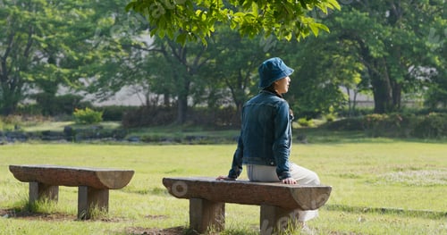 Preview: Woman sits on the wooden bench