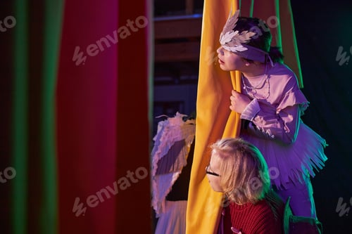 Preview: Two Girls Hiding behind Curtains during Play Rehearsal at Childrens Theater