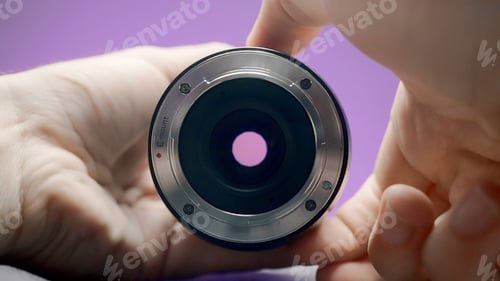 Preview: Close-up of man rotating lens. Action. Photographer turns ring of professional lens on isolated
