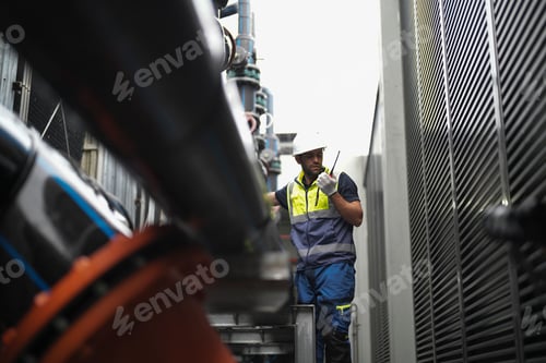 Preview: Worker inspecting industrial equipment in a manufacturing facility during daylight hours