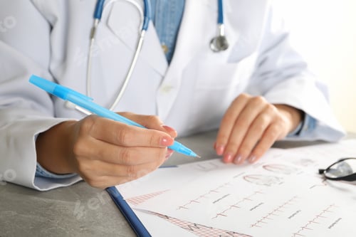 Preview: Young female doctor in medical gown checking electrocardiogram results