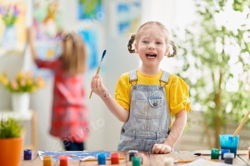 Preview: Happy kid is painting at home.