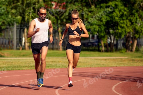 Preview: Woman and man jogging in the stadium