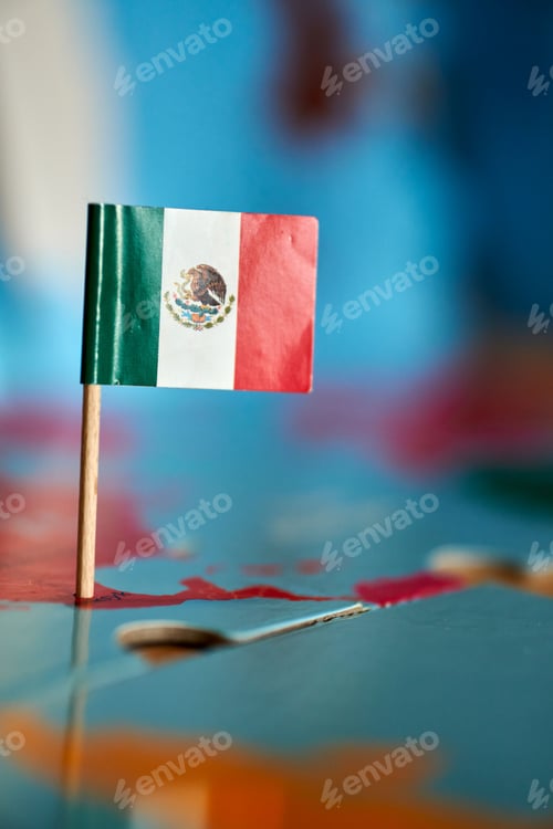 Preview: Closeup of a flag of Mexico with a small stick on the map