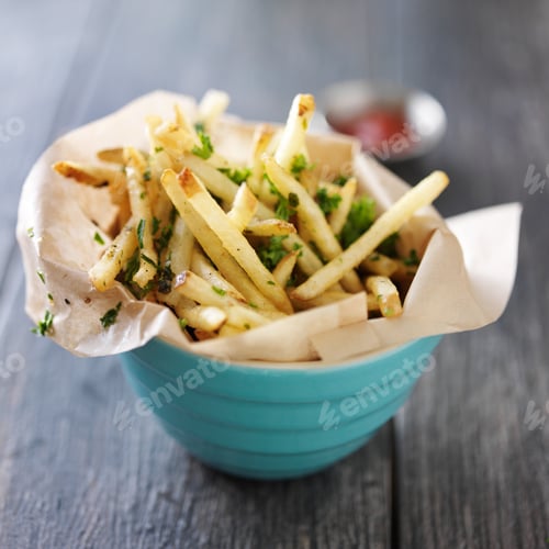 Preview: truffle fries standing up in a bowl with wax paper lining
