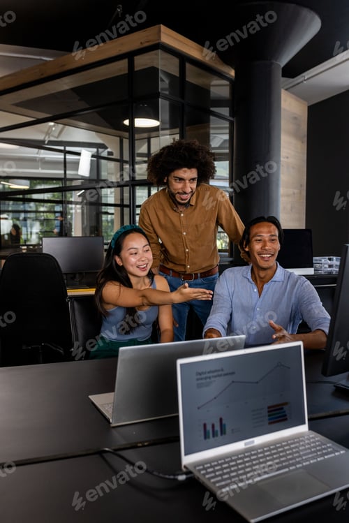 Preview: Asian woman and colleagues discussing project on computer in modern office