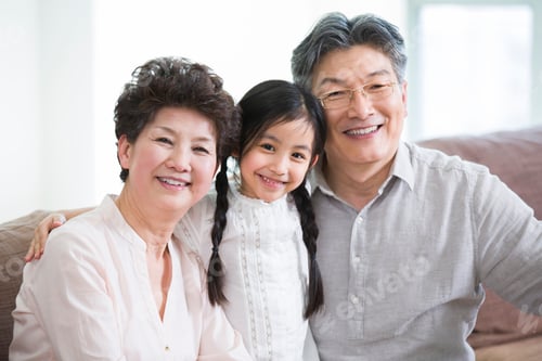 Preview: Happy girl with grandparents in living room