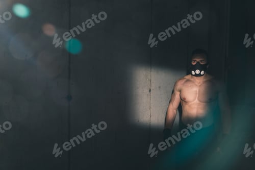 Preview: Muscular athlete wearing training mask