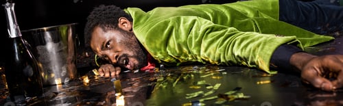 Preview: panoramic shot of drunk african american man lying on floor with shiny confetti near ice bucket and