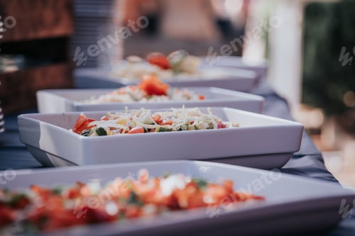 Preview: Selective focus of salads in white bowls in a row on a banquet table