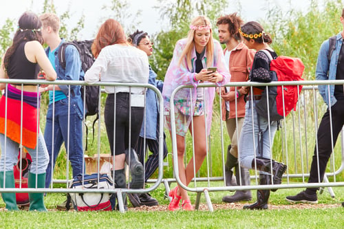 Preview: Group Of Young Friends Waiting Behind Barrier At Entrance To Music Festival Site