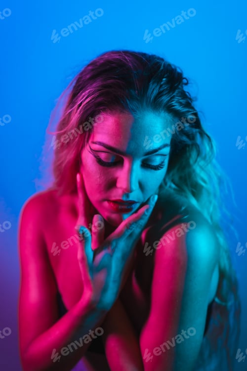 Preview: Caucasian blonde girl in a nightclub with makeup arranged on a blue background with pink neon lights