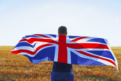 Preview: Man with a flag of Great Britain standing in field