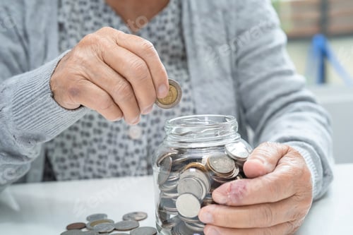 Preview: Senior Hands Placing Coin into Jar Savings