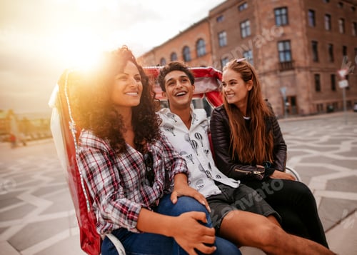 Preview: Three young people having fun on tricycle in the city