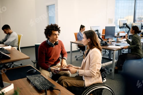 Preview: Black computer programmer and his colleague with disability working together at corporate office.