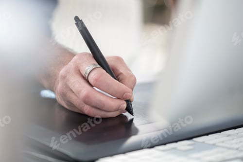 Preview: Close-up of a hand writing with a stylus on a digital tablet.