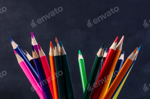 Preview: side view of a bunch of colored pencils on dark background
