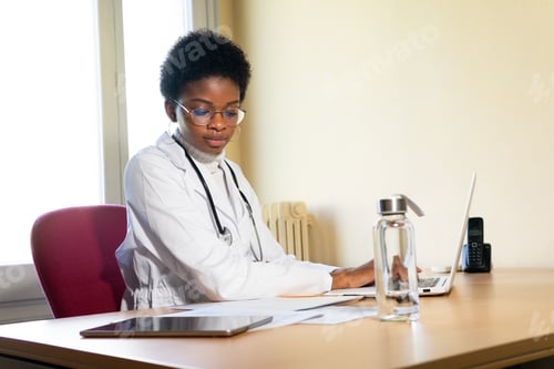 Preview: Black female doctor working with papers in office