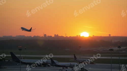 Preview: Airport view at golden sunset with an airplane taking off