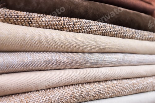 Preview: Pile of folded colorful textile. Heap of cloth brown and beige color fabric