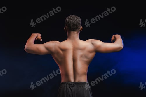 Preview: Back view of young pumped African American bodybuilder male athlete with bare torso