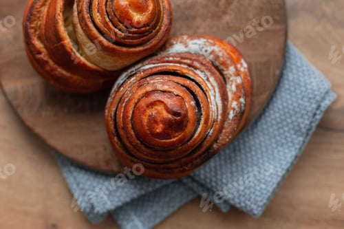 Preview: Two sweet delicious cinnamon squirrels lying on a wooden board, top view. Freshly baked