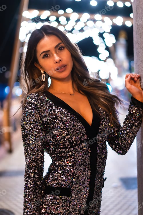 Preview: Young girl in a fashionable dress with sequins in the city christmas lights